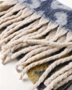 Detail shot of leopard print scarf featuring blue-grey gradients and soft cream tassels