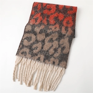 Detailed view of leopard print scarf with red gradient and white fringe tassels