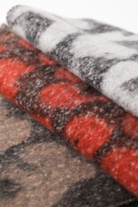 Detailed macro view of gradient leopard print scarf with thick cashmere-like texture and fringe
