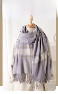 Close-up of winter scarf with soft plaid pattern in taro purple and beige tassels