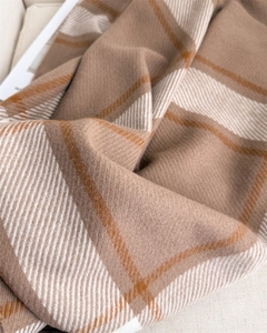 Detailed macro view of soft plaid cashmere-feel scarf with intricate twill weave texture