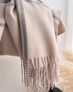 Macro detail of beige and grey plaid scarf showing soft cashmere-like twill and fringe