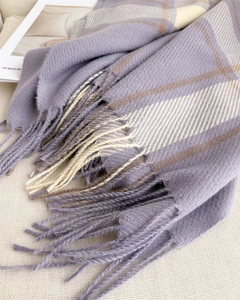 Detail of plaid scarf featuring purple and beige herringbone weave with twisted fringe