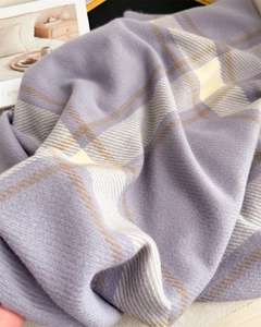 Detailed macro view of the soft plaid cashmere-like texture on a lavender scarf