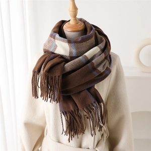Close-up of thick plaid scarf with brown and blue stripes and soft fringe details