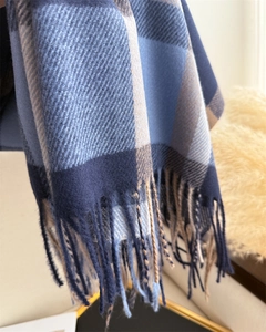 Detail showing soft cashmere-like fabric texture and fringe on checkered winter scarf