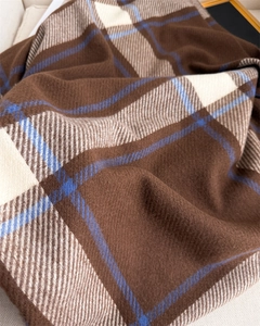 Macro texture of soft checkered cashmere scarf in coffee brown and cream white tones