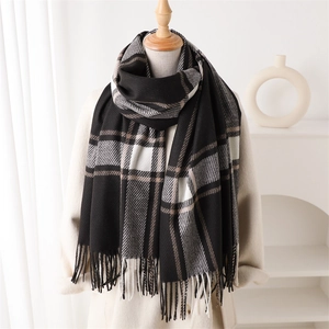 Detail of classic black and white plaid scarf with fringe tassels and soft cashmere feel