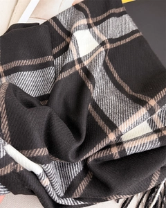 Detailed macro view of checkered cashmere-like scarf fabric with soft fringes