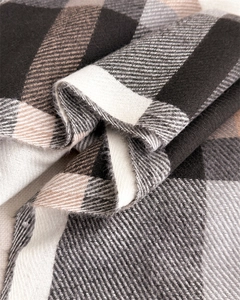 Close-up of classic plaid cashmere-like scarf showing twill weave and soft texture
