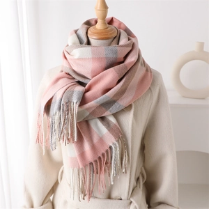 Detail of pink and grey plaid scarf texture with tassels on a mannequin in beige coat