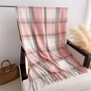 Close-up of soft pink and beige plaid scarf showing thick cashmere-like texture and long tassels