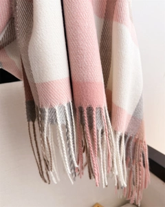 Detailed view of pink and grey plaid scarf featuring soft texture and fringe tassels