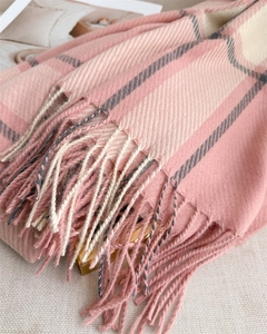 Detailed texture of pink and beige plaid cashmere scarf with soft fringe tassels