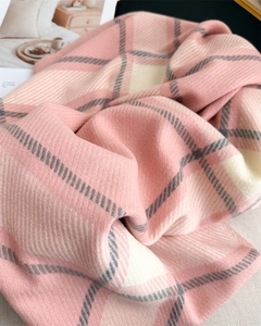 Close-up of soft pink and white plaid knit texture on faux cashmere winter scarf