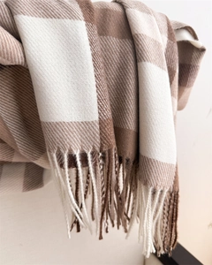 Detail of soft brown and beige plaid scarf showing thick cashmere-like texture and tassels