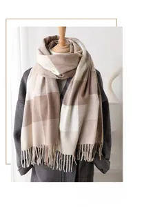 Détail d'une écharpe à carreaux en cachemire synthétique portée sur un manteau gris