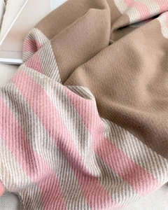 Close-up of thick twill woven cashmere-like scarf with camel and pink stripe texture