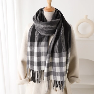 Classic plaid color block cashmere-like scarf with tassels on a mannequin in a beige coat