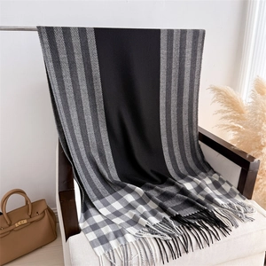 Detail shot of plaid tassel scarf showing knit texture and color-blocked fringe detail