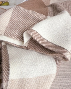 Détail macro du tissu d'écharpe à carreaux avec texture chevrons et franges douces