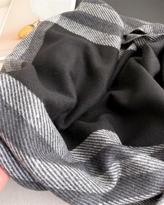 Detailed view of soft cashmere-feel fabric with black and white plaid check patterns
