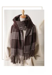 Detail view of thick brown plaid scarf with tassels styled on a wool coat