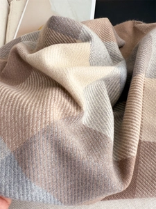 Détail d'une écharpe à carreaux douce montrant le tissage sergé et les franges