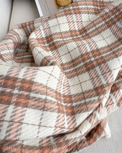 Detailed view of autumn plaid scarf with orange and beige cashmere-like knit fabric