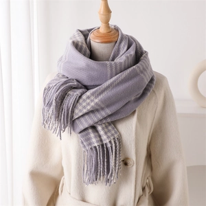 Detail of purple and beige plaid scarf showing soft cashmere-like texture and tassel trim