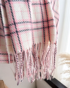 Detailed texture of pink and white checkered scarf with soft tassel fringe finish