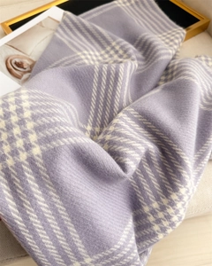 Close-up of purple and white plaid scarf featuring soft faux cashmere texture and tassels