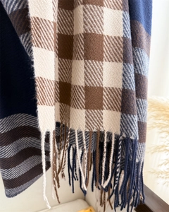 Detail of plaid cashmere-like scarf showing texture and elegant fringe tassels
