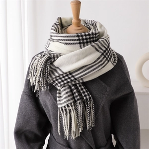 Close-up of black and white plaid scarf texture with fringe on wool coat display