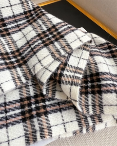 Close-up of soft cashmere-feel fabric with vintage plaid pattern and herringbone texture
