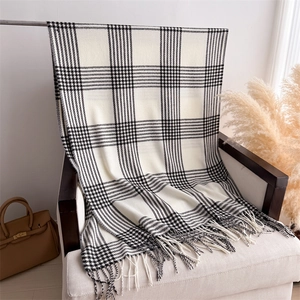 Close-up of black and white checkered scarf with soft tassel detail on fabric