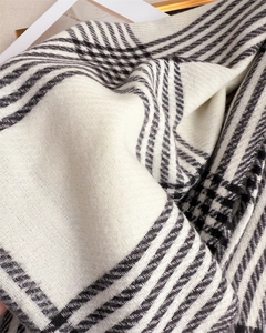 Close-up of black and white herringbone check scarf showing soft cashmere-like texture