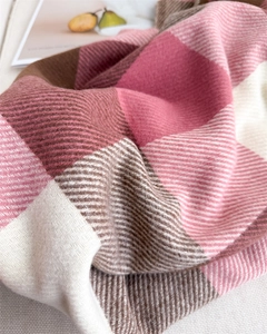 Détail d'une écharpe à carreaux montrant une texture sergé aspect cachemire rose et crème