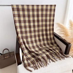 Close-up of classic plaid scarf with soft fringe in brown and yellow tones