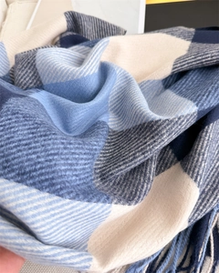 Vue macro d'une écharpe à carreaux bleus et blancs avec tissage sergé et finitions franges
