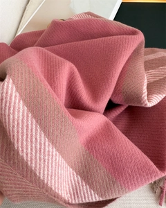 Detail of pink plaid cashmere-like scarf showing soft twill weave texture and fringe edges