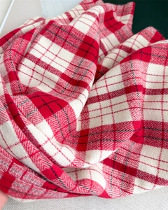 Close-up of red and white plaid scarf fabric showing soft cashmere-like twill texture