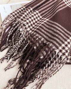 Detail of coffee and beige checkered scarf with tassels and soft cashmere-like texture