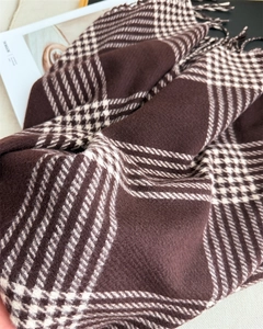 Close-up of thick plaid scarf with brushed texture and hand-tied fringe detailing