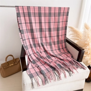 Detail shot of soft pink and grey plaid scarf with fine tassels on an elegant chair