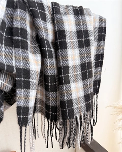 Detailed view of soft plaid scarf featuring classic monochrome pattern and long fringe trim
