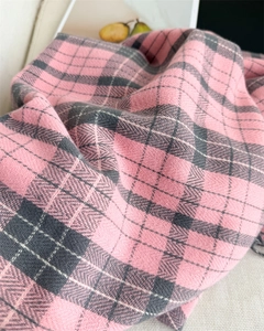 Close-up of pink and grey plaid scarf featuring refined herringbone knit texture