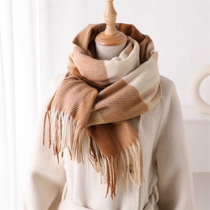 Détail d'une écharpe pashmina à carreaux marron chaud avec franges et motif classique