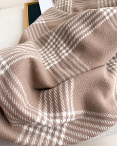 Macro shot of thick winter plaid scarf with soft twill weave and fringe details