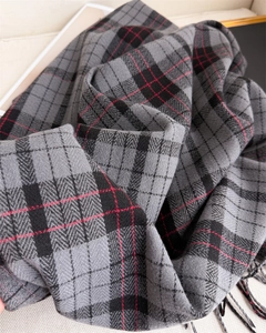 Detailed close-up of cashmere-style plaid scarf with herringbone weave and fringe detail